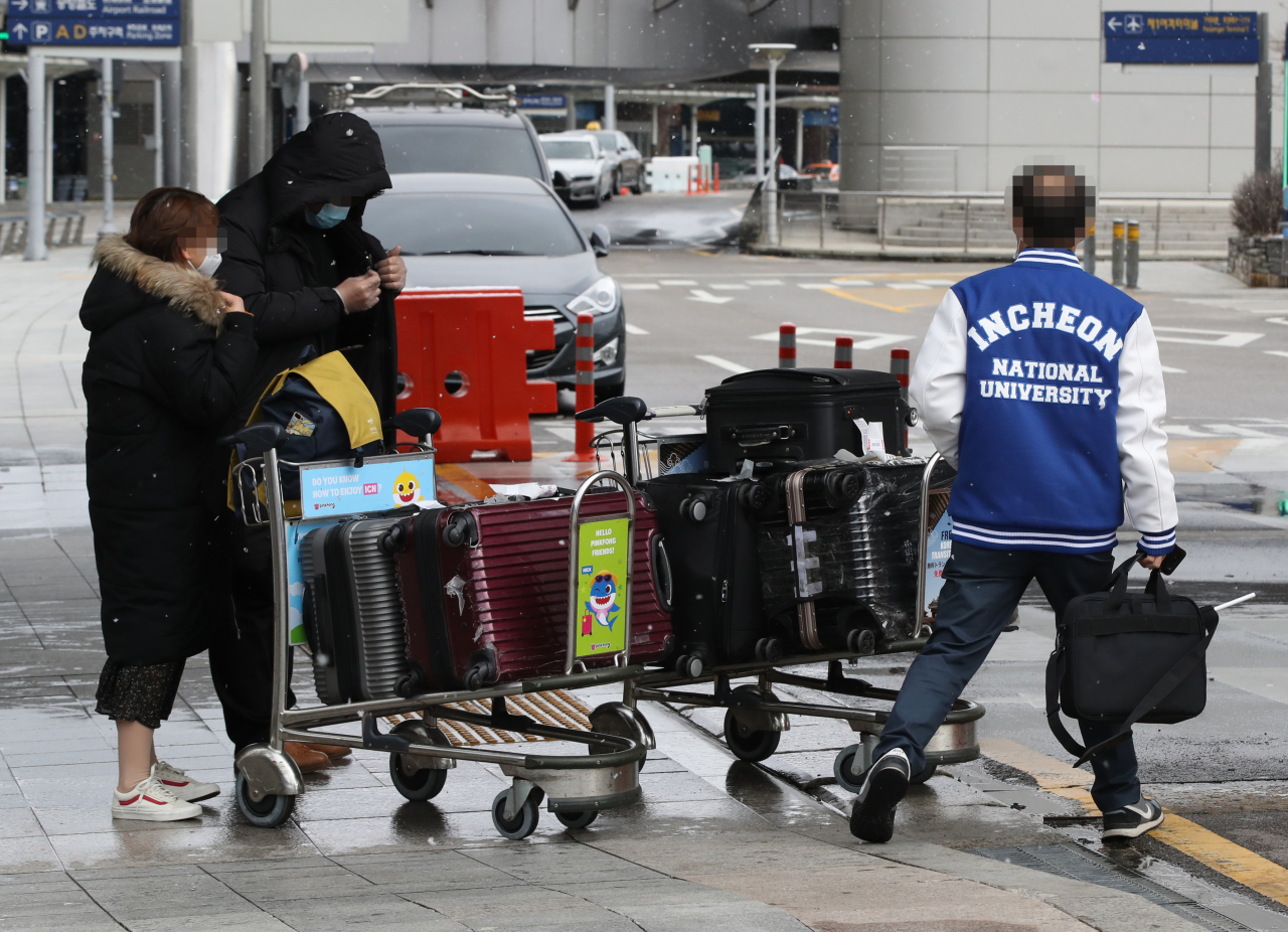 지난 16일 오후 인천 중구 인천국제공항 제1터미널 입국장에서 인천대 관계자가 중국인 유학생을 학교 기숙사로 향하는 콜밴으로 안내하고 있다. 인천대는 방학기간 중국에 머물다 인천공항을 통해 입국하는 중국인 유학생들을 학교 직원의 안내를 받아 콜밴을 타고 학교 기숙사까지 이동시키고 있다. 이들은 14일간 기숙사에서 격리 생활을 하게 된다. [연합]