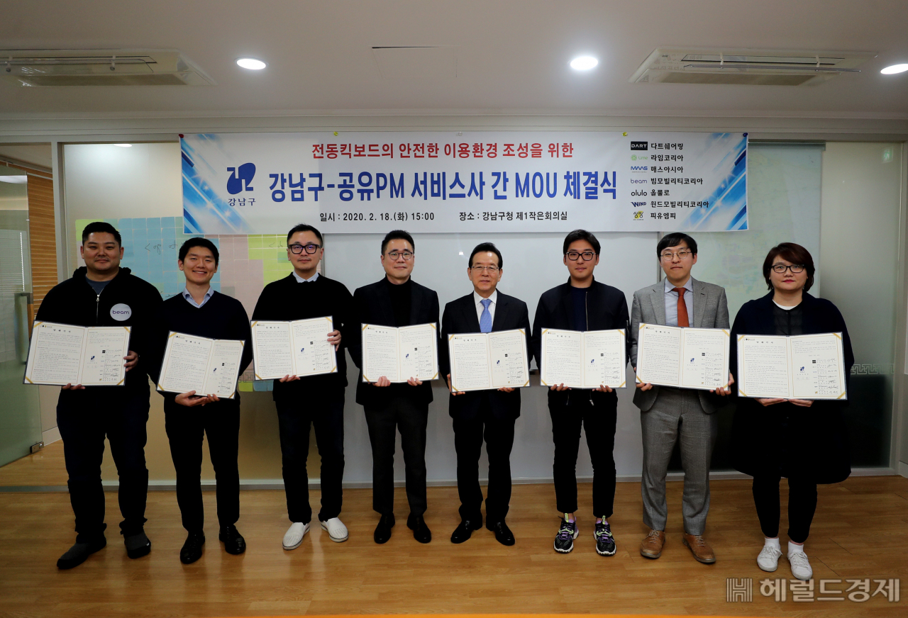 정순균 구청장(왼쪽에서 다섯번째)과 공유 전동킥보드 업체 대표들이 18일 교통 안전 관련 업무협약서를 들어보이고 있다. [강남구]