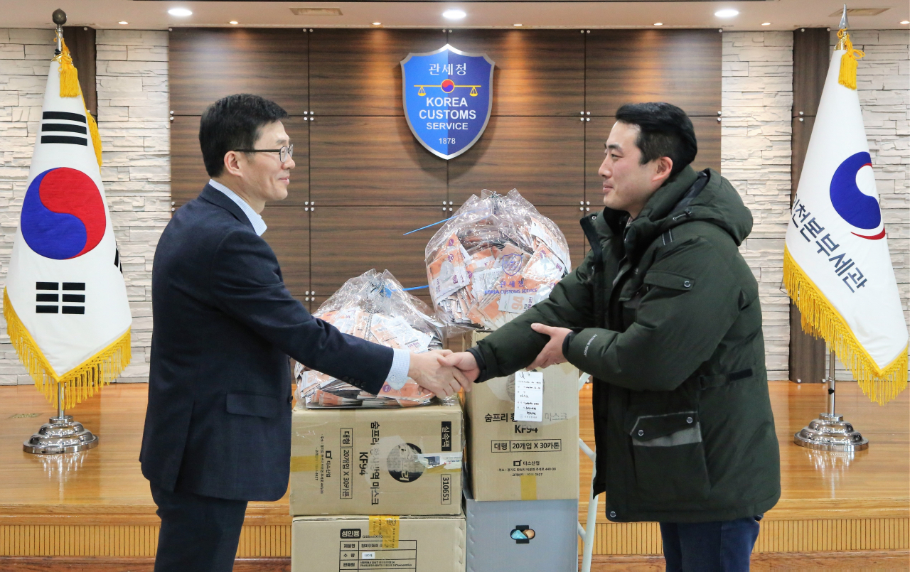 인천세관 통관지원과 양을수 과장(왼쪽)이 한국사회복지협의회 산하 인천 푸드마켓 유현우 사회복지사(우측)에게 마스크를 전달하고 있다.