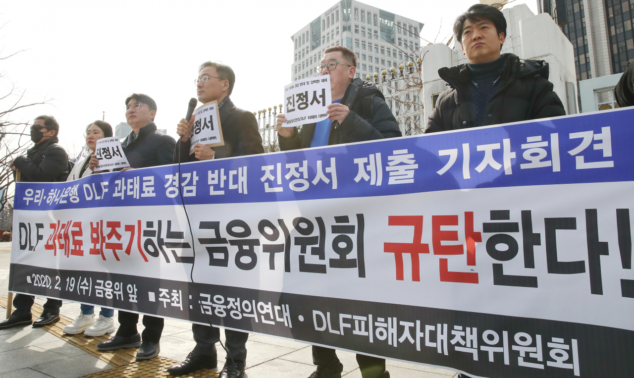 DLF피해자 및 금융정의연대 관계자들이 19일 오후 금융위원회가 있는 정부서울청사 앞에서 '우리·하나은행 DLF 과태료 경감 반대' 기자회견을 하고 있다. [연합]