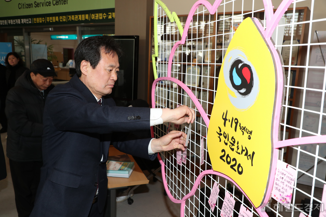 박겸수 구청장이 19일 4·19혁명국민문화제 위원회 출범식에서 4·19혁명 60주년 염원을 쪽지에 적어 걸고 있다. [강북구 제공]