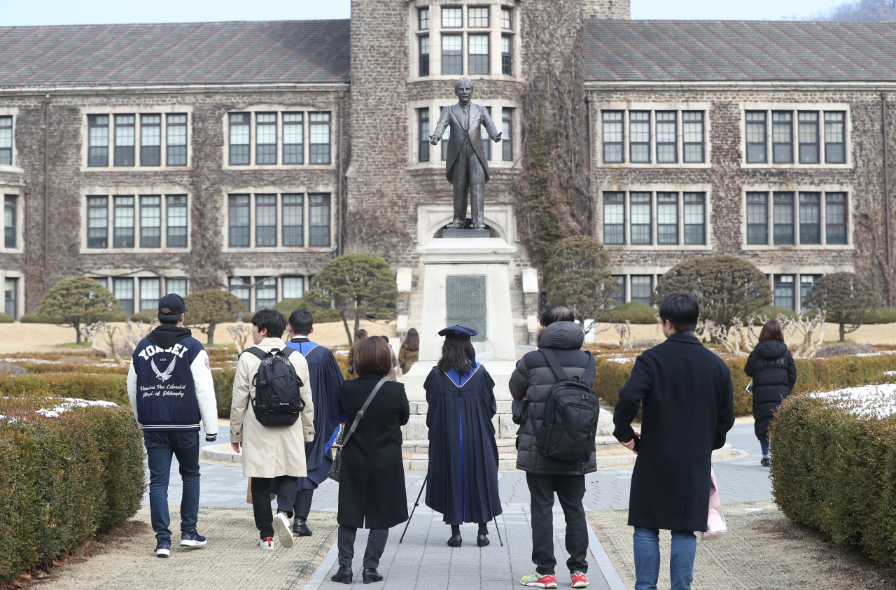지난 19일 서울 연세대학교에서 졸업가운을 입은 학생들이사진 촬영을 하고 있는 모습. 연세대는 신종 코로나바이러스 감염증 확산 방지를 위해 2월 학위수여식을 취소하고 이날부터 희망 학생들에게 졸업가운과 학사모를 대여하고 있다. [연합]