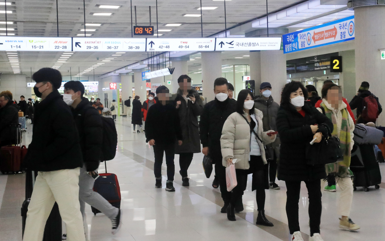 제주국제공항 이용객들이 마스크를 착용하고 빠르게 발걸음을 옮기고 있다. [연합]