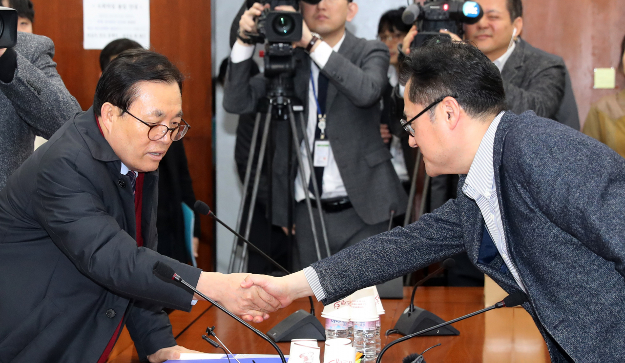 국회 행안위 미래통합당 간사인 이채익 의원(왼쪽)과 민주당 간사인 홍익표 의원(오른쪽)이 지난 13일 오전 서울 여의도 국회에서 국회의원 선거구 획정 논의를 위한 간사회동에서 악수하고 있다. [연합]