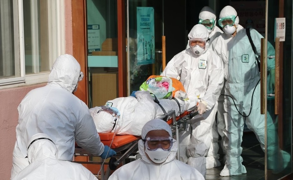Medical workers transfer a suspected coronavirus patient from Daenam Hospital in Cheongdo, 320 kilometers southeast of Seoul, to another hospital on Feb. 21, 2020. Of about 600 patients and medical staff at the hospital, 16 tested positive for COVID-19, health authorities said. (Yonhap)