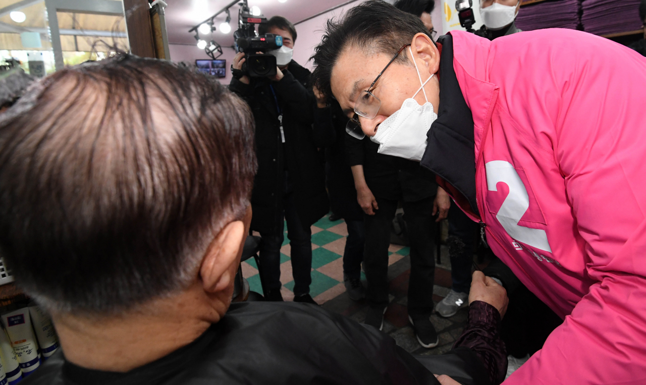 황교안 미래통합당 대표가 21일 서울 종로구 탑골공원 인근 이발소를 방문해 이발하던 손님에게 인사하고 있다. [연합]