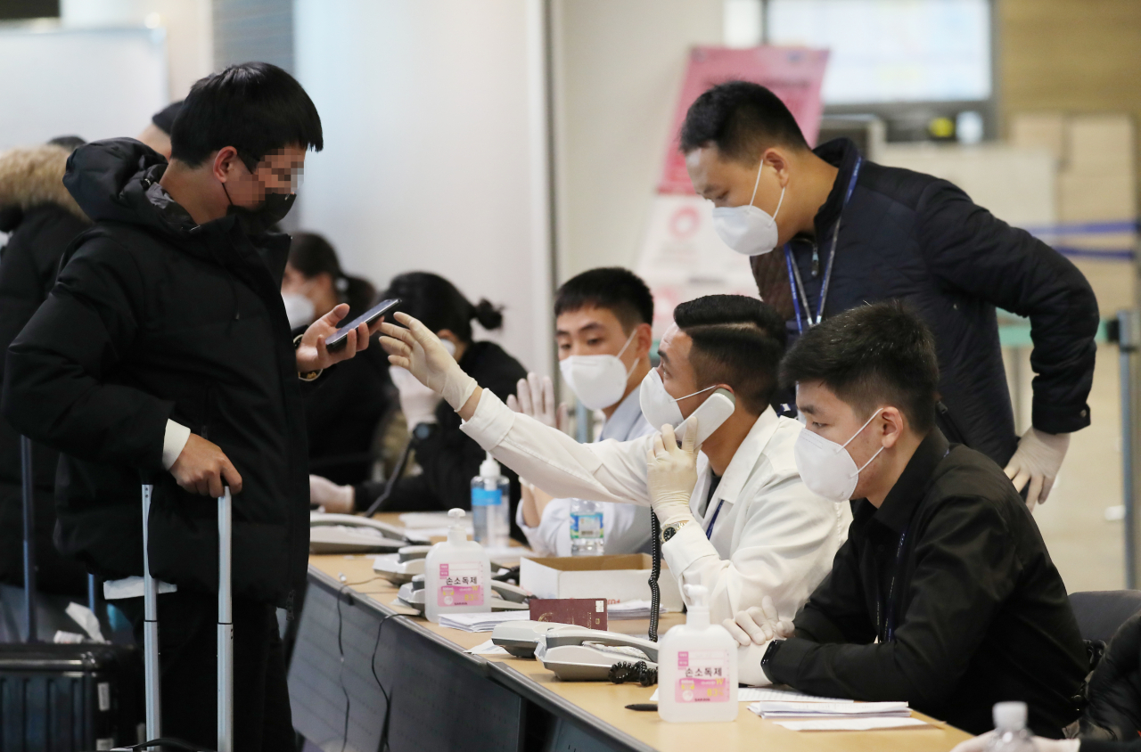 5일 오전 인천국제공항 1터미널에서 중국발 여객기를 타고 도착한 승객들이 검역대를 통과해 중국 전용입국장에서 국내 연락처를 확인받고 있다. 연합뉴스