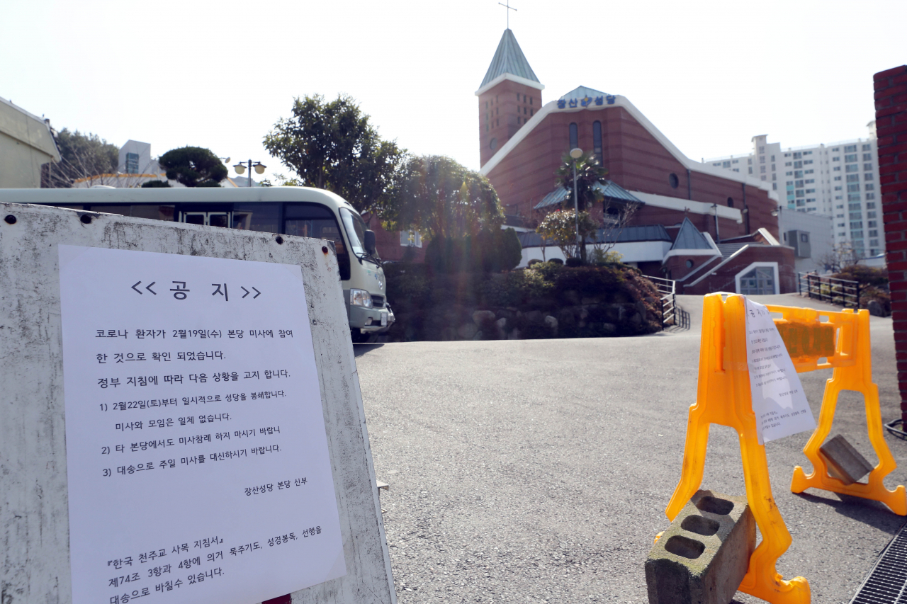 22일 부산 장산성당 입구에 일시 봉쇄를 알리는 게시문이 붙어 있다. 부산시가 해운대구에 사는 50대 신종 코로나바이러스 감염증(코로나19) 확진자를 상대로 동선을 파악한 결과 지난 19일 장산성당에서 예배를 본 것으로 나타났다. [연합]