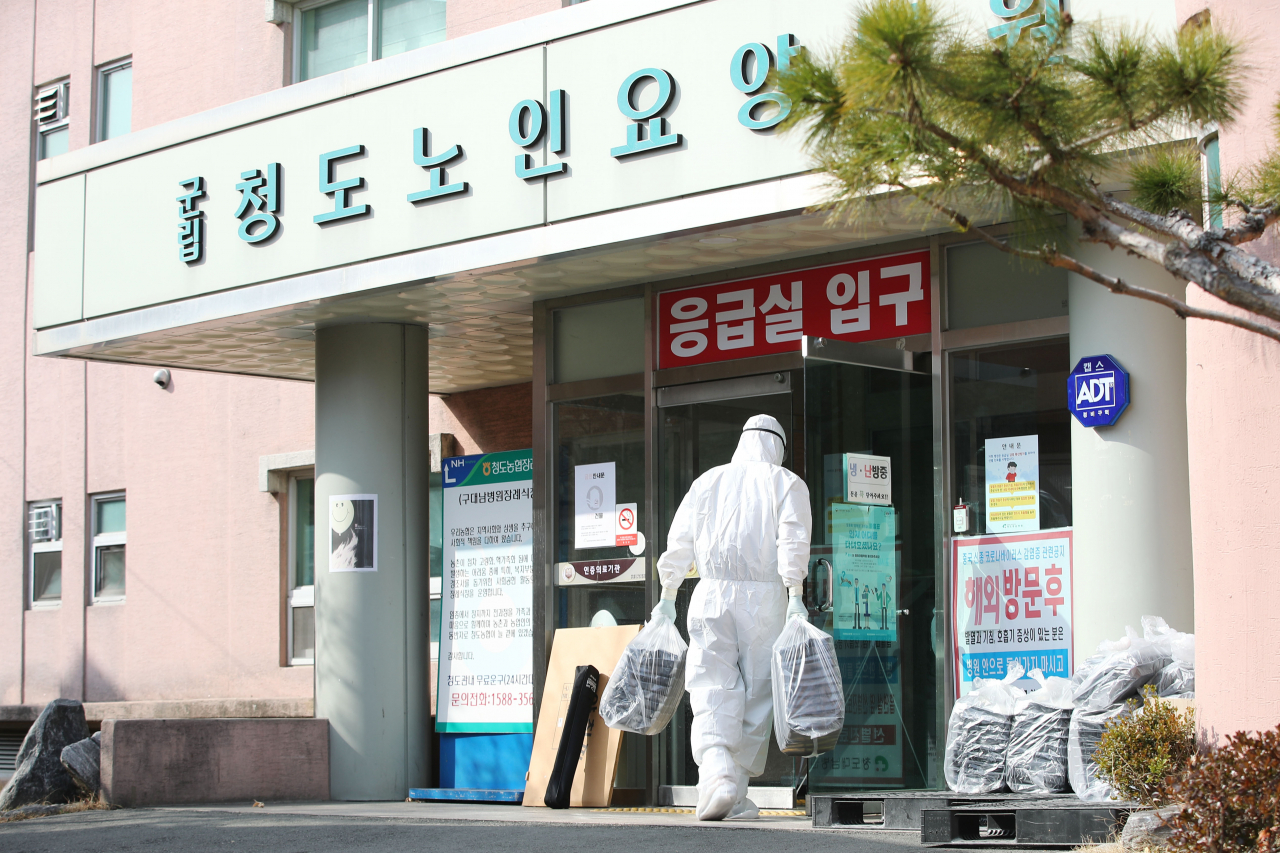 22일 오후 경북 청도대남병원에서 방호복을 입은 의료진들이 도시락을 옮기고 있다. 연합뉴스
