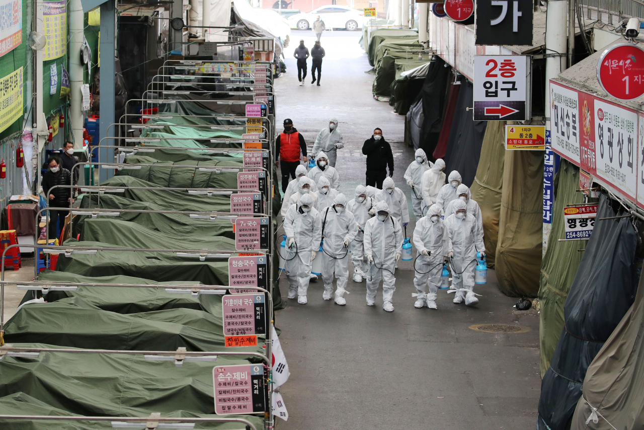 23일 오후 신종 코로나바이러스 감염증(코로나19) 여파로 임시휴업을 한 대구시 중구 서문시장에서 상가연합회 관계자들이 방역작업을 하고 있다. 연합뉴스