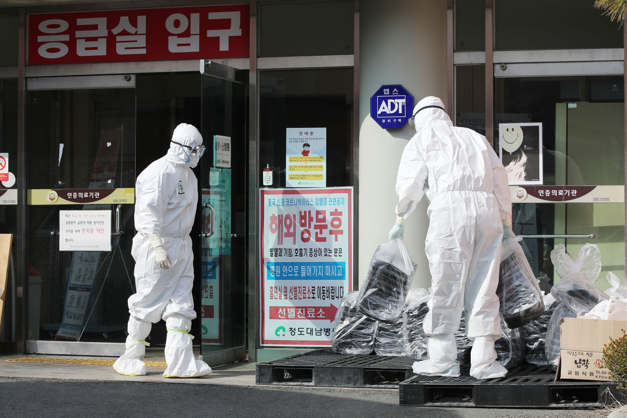 22일 오후 경북 청도대남병원에서 방호복을 입은 의료진들이 도시락을 옮기고 있다. 연합뉴스