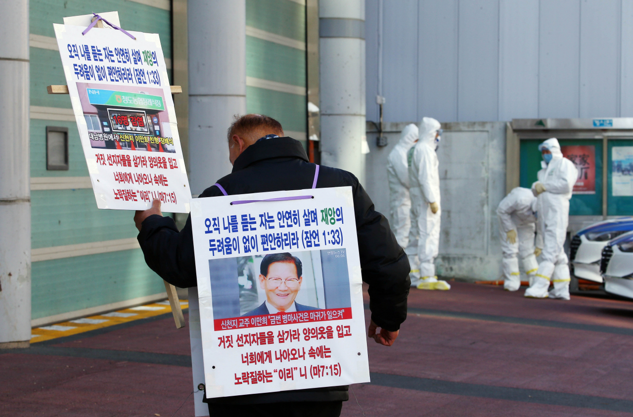 23일 신천지 교인 1명이 팻말을 들고 대구 북부소방서를 찾아와 소방서 관계자들과 얘기를 나누기 위해 기다리고 있다. 연합뉴스