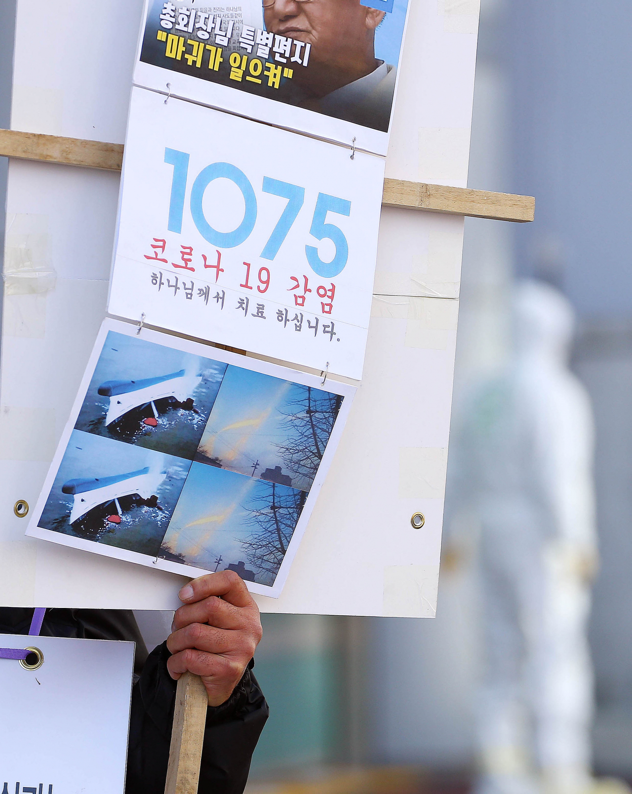 23일 신천지 교인 1명이 팻말을 들고 대구 북부소방서를 찾아와 소방서 관계자들과 얘기를 나누기 위해 기다리고 있다. 연합뉴스