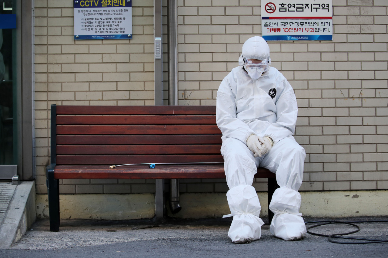 A health worker sits outside a hospital in Daegu on Sunday. (Yonhap)