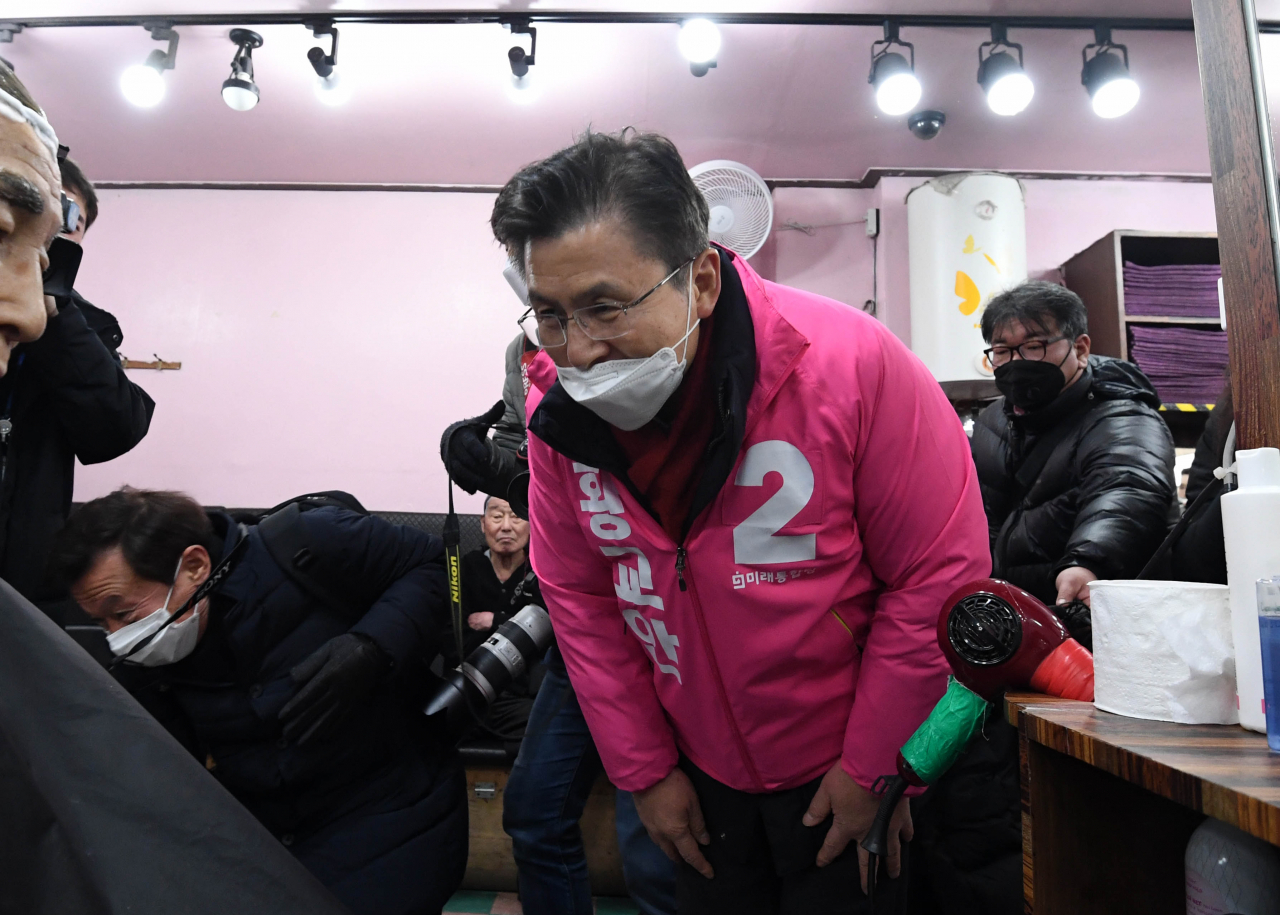 황교안 미래통합당 대표가 지난 21일 서울 종로구 탑골공원 인근 이발소를 방문해 이발하던 손님에게 인사하고 있다. [연합]