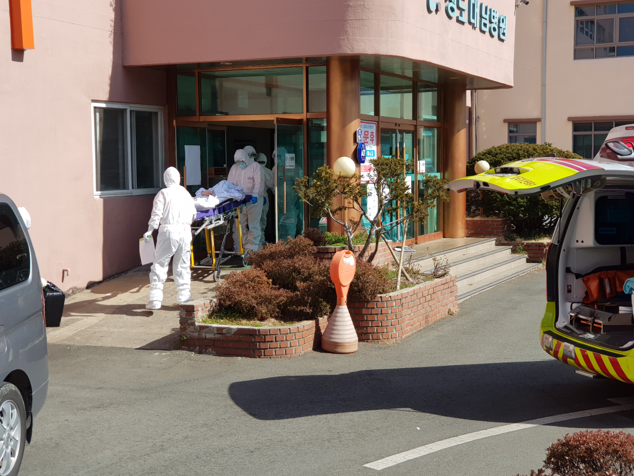 Quarantine officials transport a patient out of Daenam Hospital in Cheongdo, North Gyeongsang Province. Yonhap