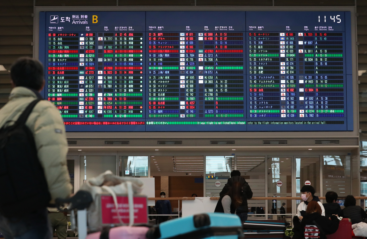 신종 코로나바이러스 감염증 확산이 우려되고 있는 가운데, 인천국제공항 2터미널 입국장에서 이용객이 현황판을 바라보고 있다. [연합]