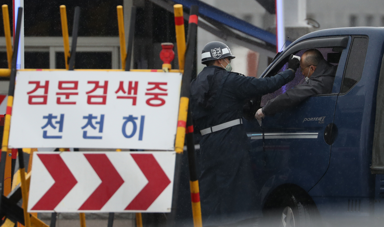 국방부는 25일 군내 코로나19 확진자가 전날보다 5명 늘어난 총 18명이라고 밝혔다. 대구 공군기지에서 출입하는 차량 운전자의 발열을 체크하고 있다. [연합]