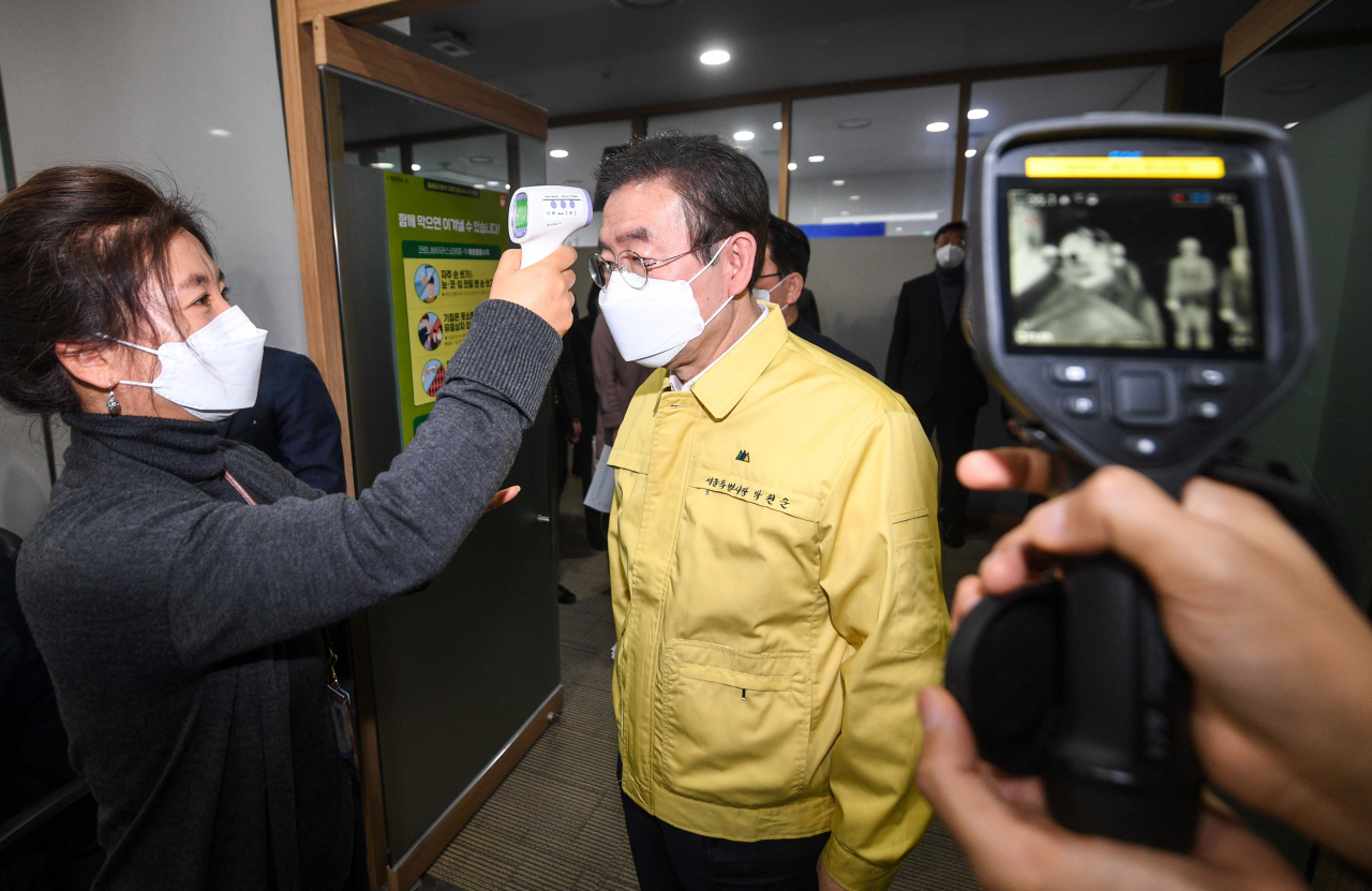 박원순 서울시장이 지난 25일 서울 시청 기획상황실에서 열린 코로나19 관련 긴급 비상대책회의에 참석하며 발열 체크를 하고 있다. [연합뉴스]