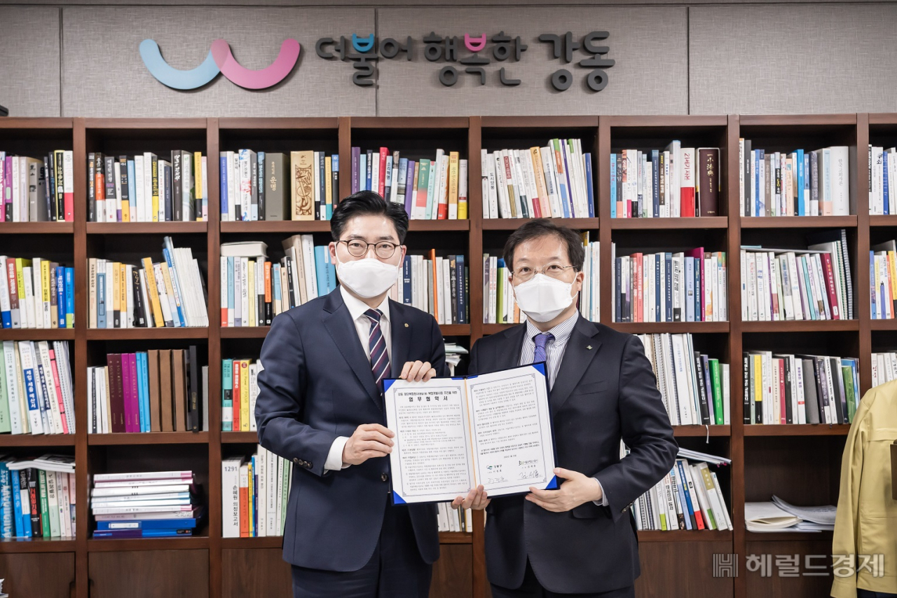 이정훈(왼쪽) 강동구청장과 김세용 SH공사 사장이 26일 구청장실에서 명일1동 주민센터 등 공공청사 복합개발을 위한 업무협약서에 서명한 뒤 협약서를 들어보이고 있다. [강동구 제공]
