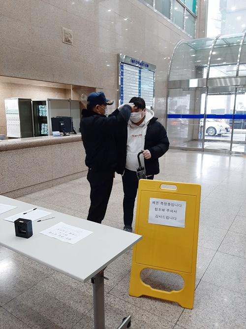 무역협회 광주전남지부가 무역회관 방문객을 상대로 발열검사를 하고 있다.