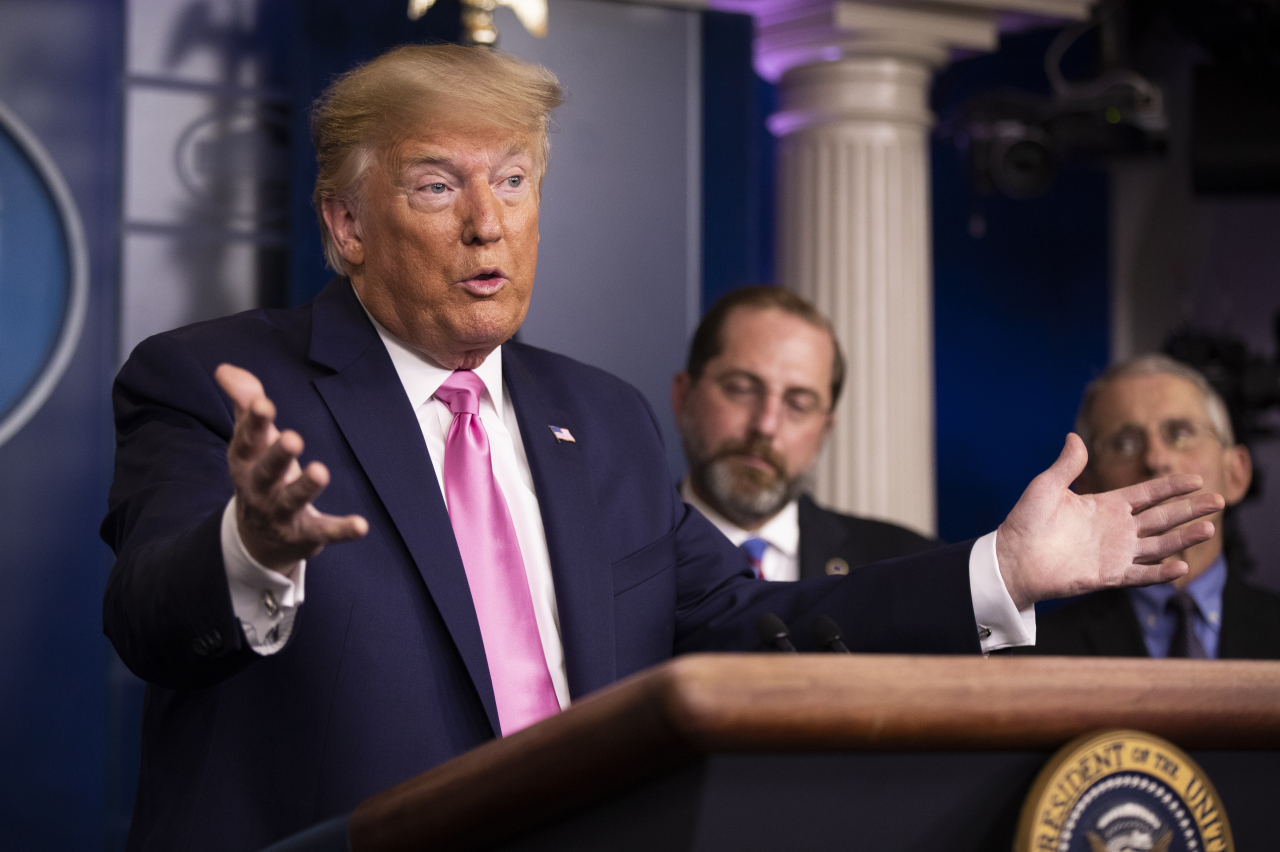 President Donald Trump with Department of Health and Human Services Secretary Alex Azar, back center, and Director of the National Institute of Allergy and Infectious Diseases at the National Institutes of Health Anthony Fauci, right, and other members of the president's coronavirus task force speaks during a news conference at the Brady press briefing room of the White House, Wednesday in Washington. (AP-Yonhap)