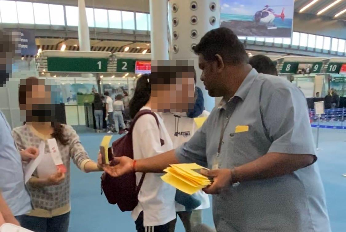 자국 내 코로나19 확산을 막아야 한다는 이유로 아프리카 섬나라 모리셔스로부터 입국을 거부당한 신혼부부 가운데 일부가 26일 인천공항을 통해 귀국했다. 사진은 모리셔스의 공항에서 현지 출입국 당국 관계자가 우리 국민의 여권을 수거하는 모습. [연합뉴스 독자 제공. 재판매 및 DB 금지]