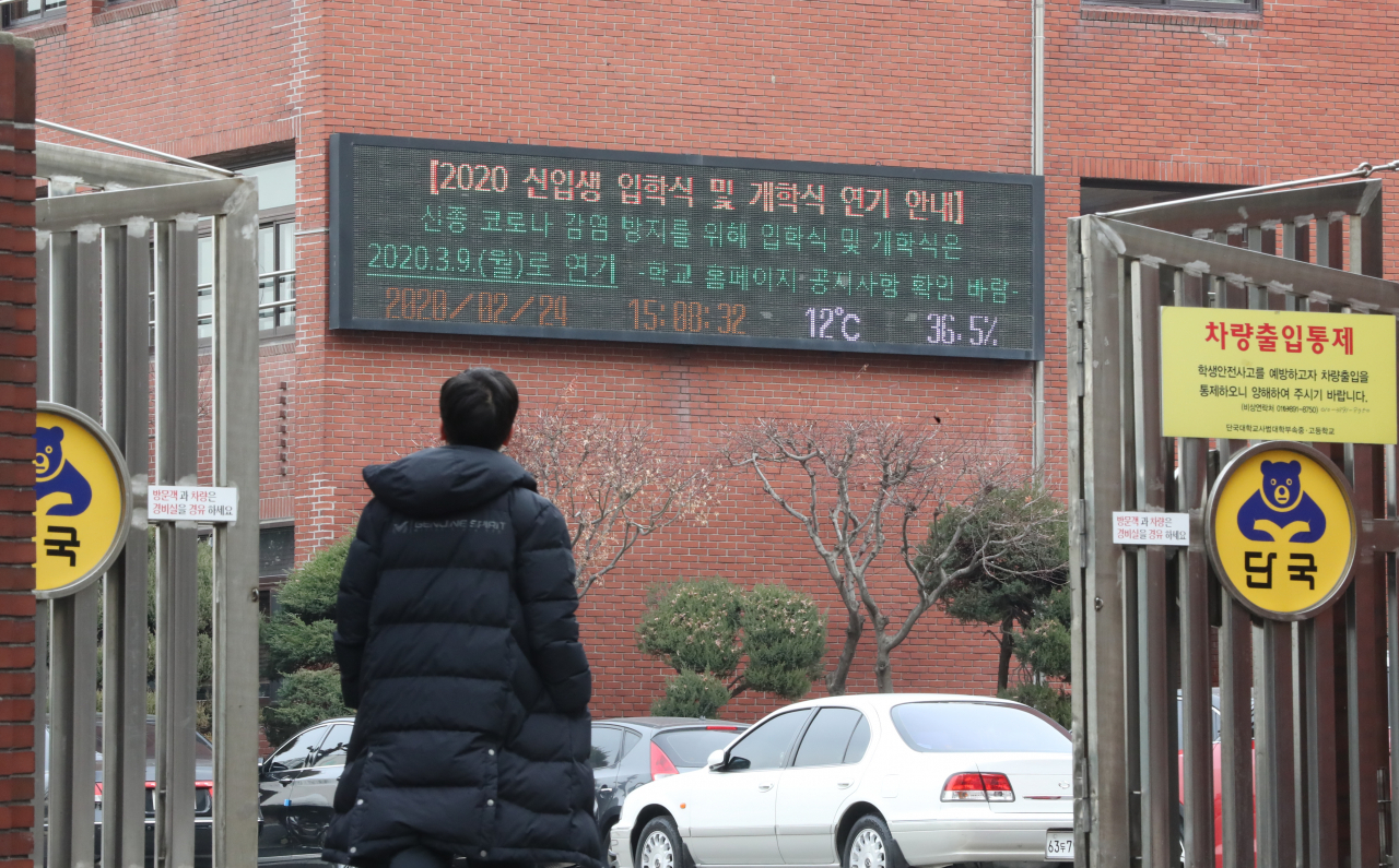 지난 24일 오후 서울 강남구의 한 고등학교 외벽에 설치된 전광판에 개학식 연기 안내문이 나오고 있다. [연합]