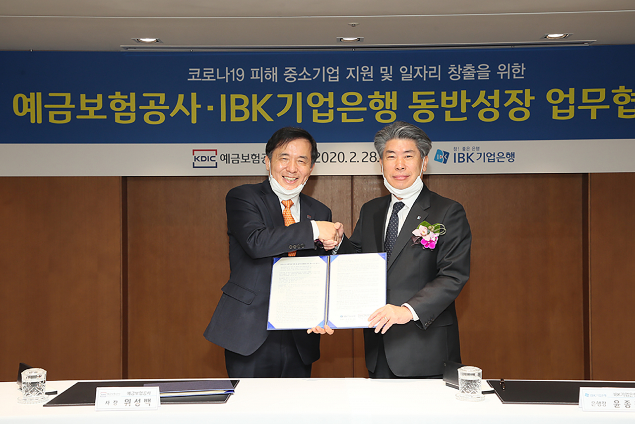 [사진=예금보험공사와 기업은행은28일 코로나19 피해기업 지원 및 일자리 창출을 위한 동반성장 업무협약을 체결했다. 위성백 예금보험공사 사장(왼쪽)과 윤종원 기업은행 행장(오른쪽)이 협약 체결 후 기념촬영을 하고 있다.]