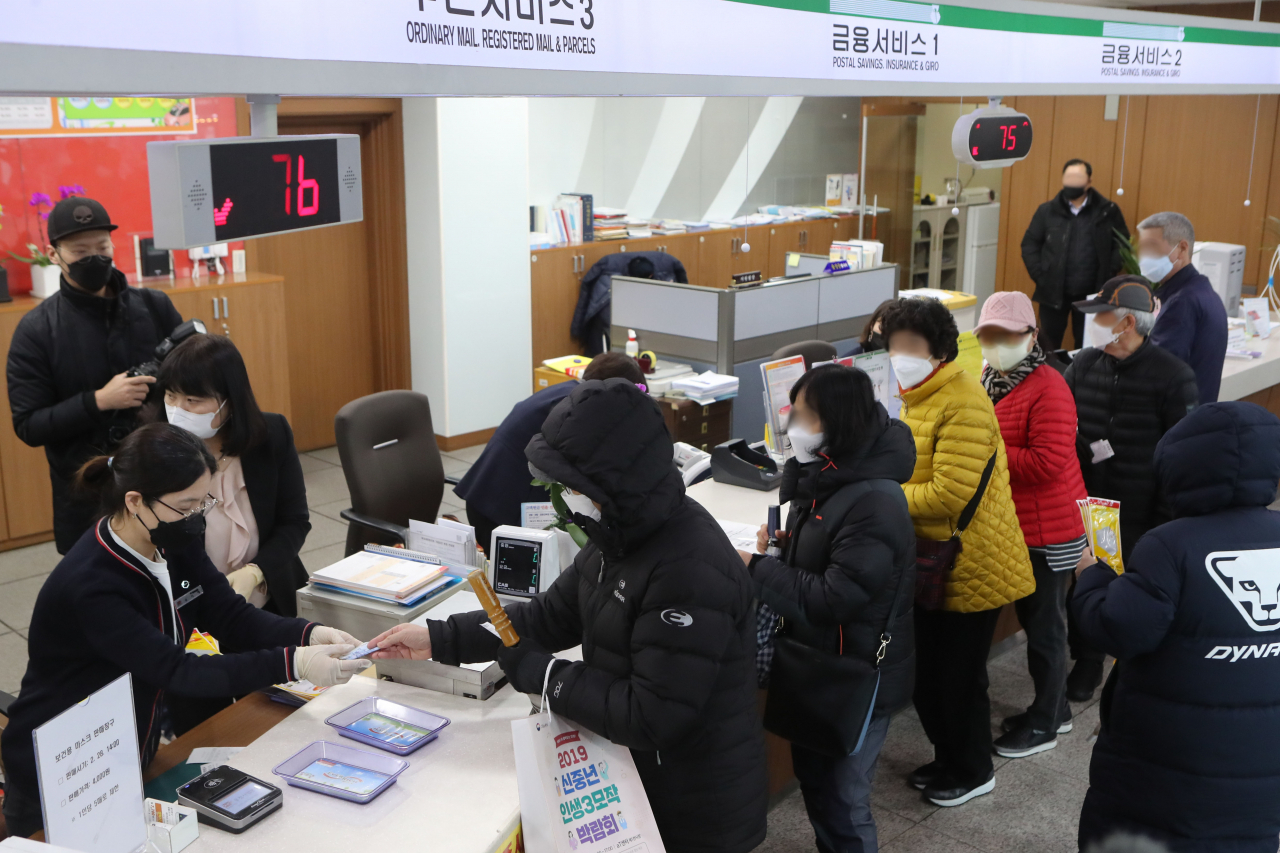 28일 경기도 파주시 문산우체국에서 신종 코로나바이러스 감염증(코로나19) 여파로 시민들이 줄을 지어 마스크를 구매하고 있다. 우체국은 이날 오후 2시부터 번호표를 배부할 예정이었으나, 오전부터 줄을 선 시민들의 숫자가 준비한 판매수량을 넘으면서 마스크 판매는 시작 전에 마감됐다. [연합]