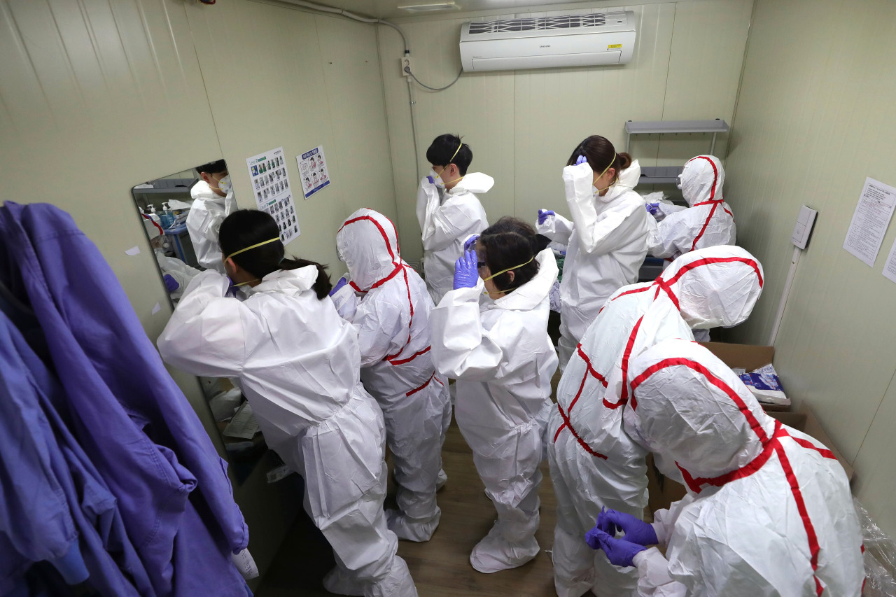 Staff at a COVID-19 testing facility make preparations in Daegu on Friday. Yonhap