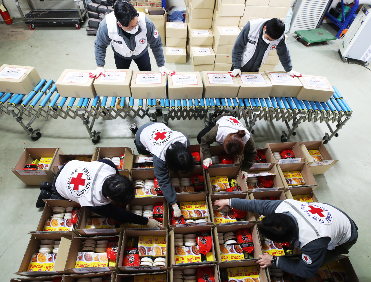 28일 오후 경기도 수원시 대한적십자사 경기도지사에서 직원들이 신종 코로나바이러스 감염증(코로나19) 자가격리자를 위해 즉석밥, 생수, 라면, 통조림 등으로 구성된 긴급구호세트를 제작하고 있다. 연합뉴스