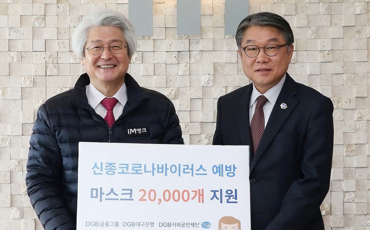 김태오 DGB금융그룹 회장(왼쪽)이 신종 코로나바이러스 예방을 위해 3일 이승호 대구시 경제부시장에게 지역 자활근로자들에게 나눠줄 마스크 2만장을 전달했다. 연합뉴스