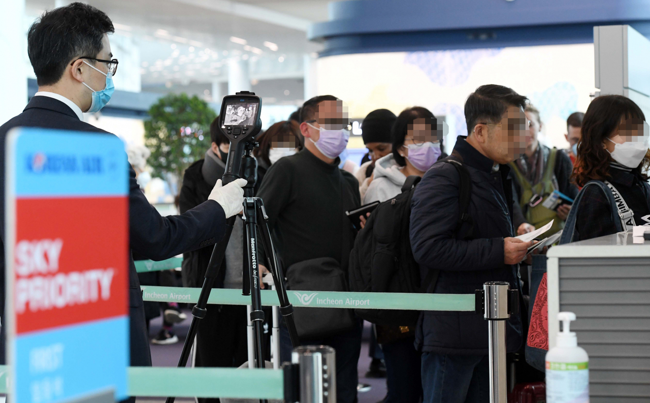 28일 오후 인천국제공항 2터미널 인천발 로스앤젤레스(LA)행 KE017편 탑승구 앞에서 대한항공 직원들이 탑승 승객의 발열 여부를 확인하고 있다. 연합뉴스