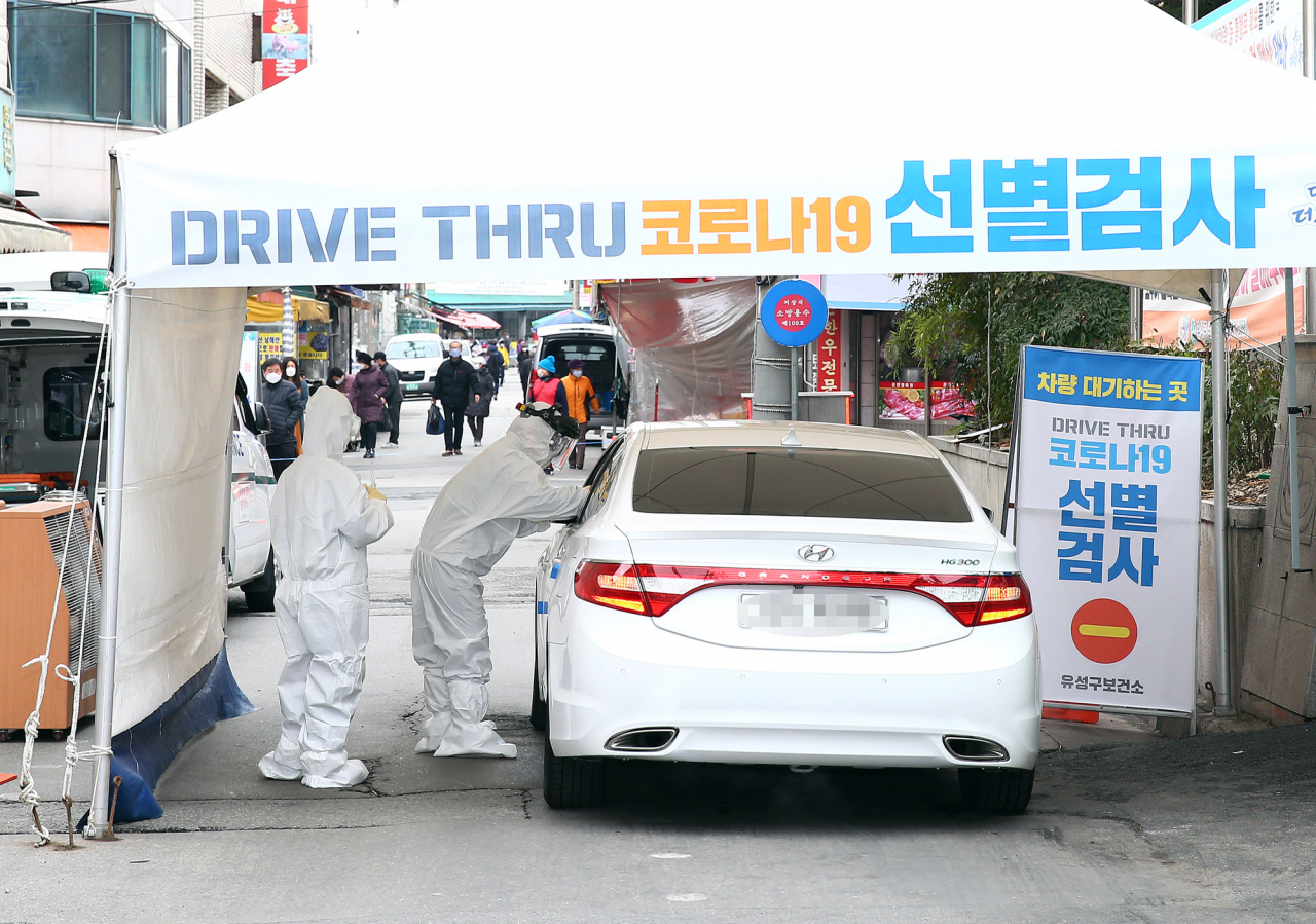 지난달 29일 대전 유성구 보건소 정문 앞 '드라이브 스루 선별진료소'에서 자가용을 몰고 온 한 시민이 신종 코로나바이러스 감염증 검사를 받고 있다. [연합]