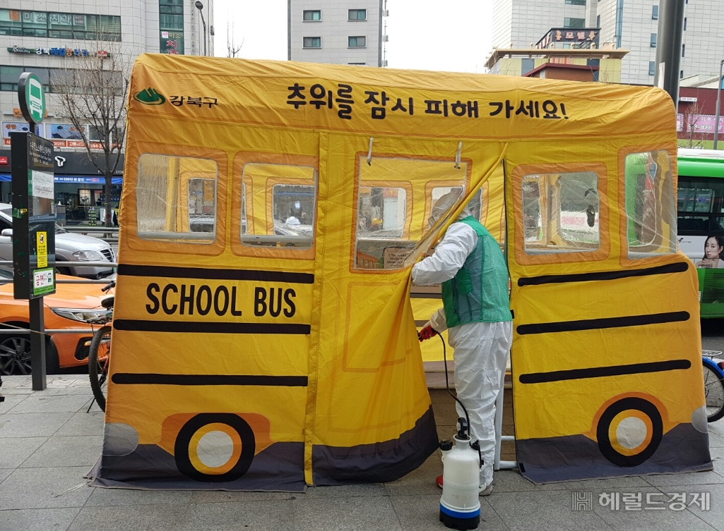 강북구 번1동 새마을지도자협의회 회원이 지난달 24일 버스정류장 따숨터 내부를 소독하고 있다. [강북구 제공]