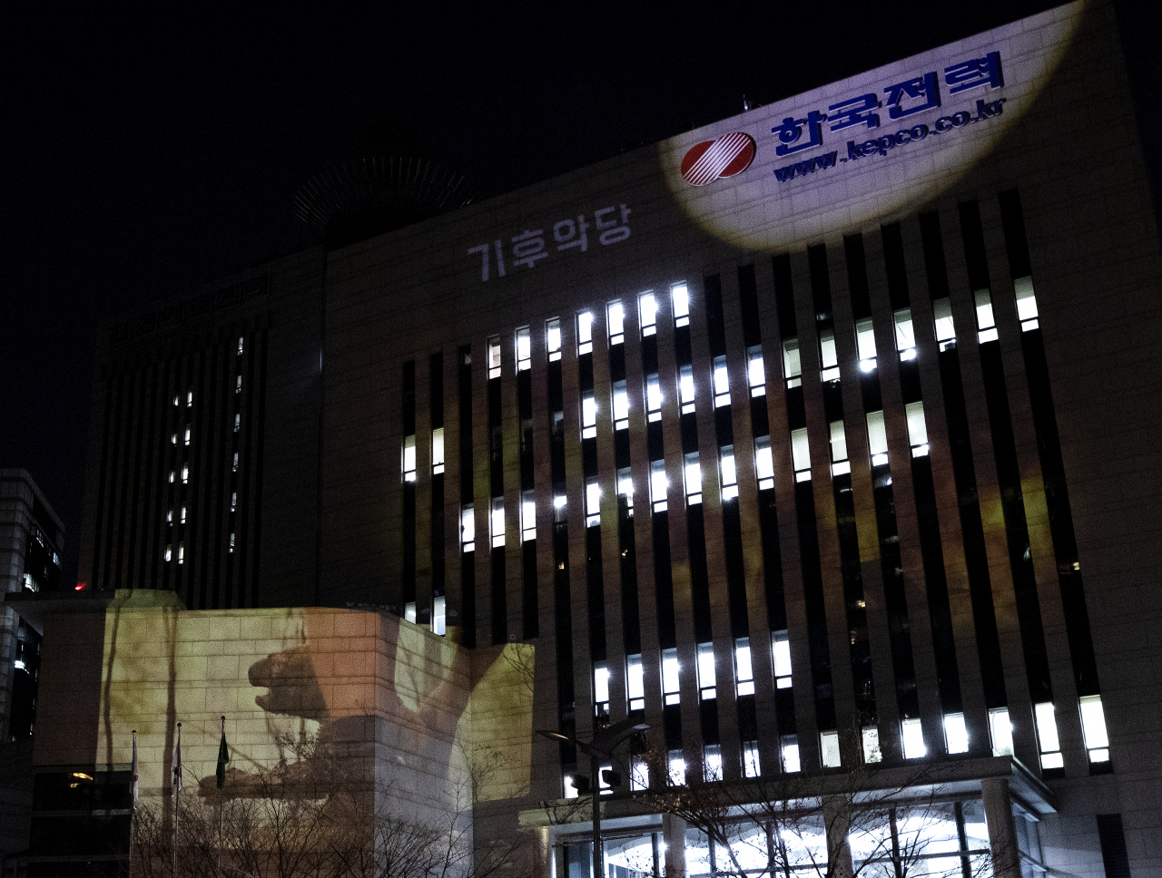 국제환경단체 그린피스 서울사무소 관계자들이 최근 서울 서초구 한국전력 서초지사 건물 외벽에 호주 산불 현장에서 구조되는 코알라의 모습과 항의 메시지 등을 레이저빔으로 투사하는 기후행동을 펼치고 있다. [연합]