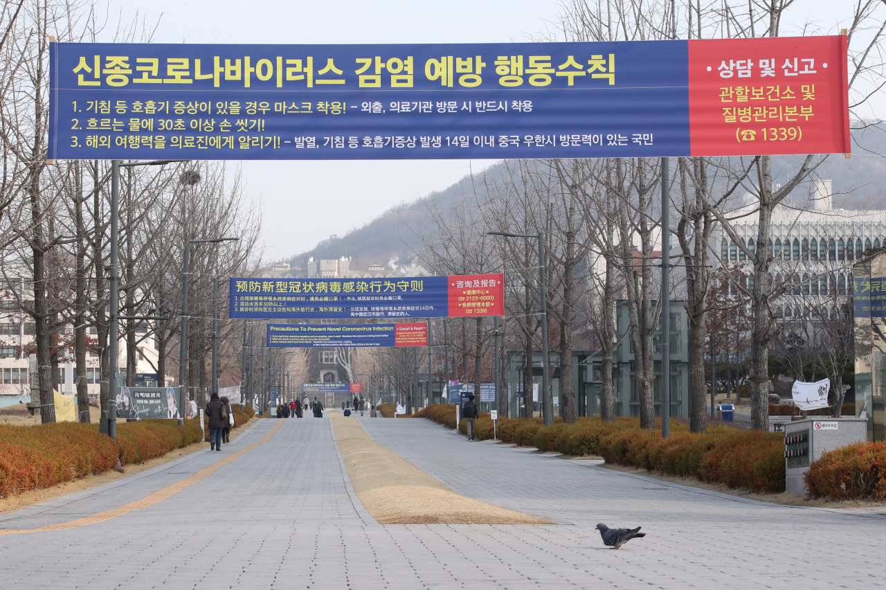 Yonsei University’s campus in Seoul is seen empty with a COVID-19 precaution banner on display Monday, the day when new school year was supposed to commence. Due to coronavirus concerns, the university has postponed the new semester by two weeks, along with other schools here.  (Yonhap)