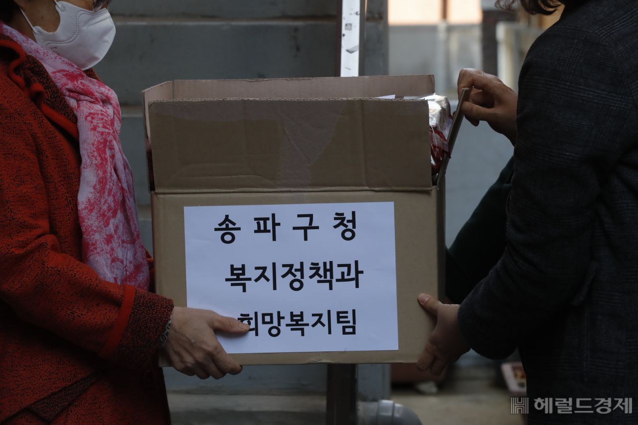 송파구청 관계자가 한 홀몸어르신에게 복지물품을 전달하고 있다. [송파구]