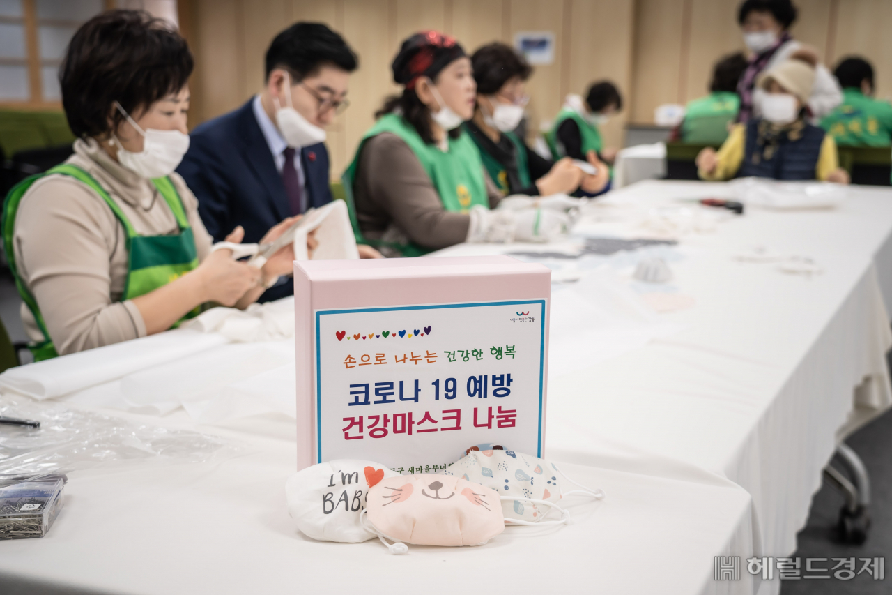 이정훈 강동구청장(안경쓴 남성)과 주민들이 면 마스크에 필터를 넣어 쓰는 코로나19 예방 마스크를 제작하고 있다. [강동구 제공]