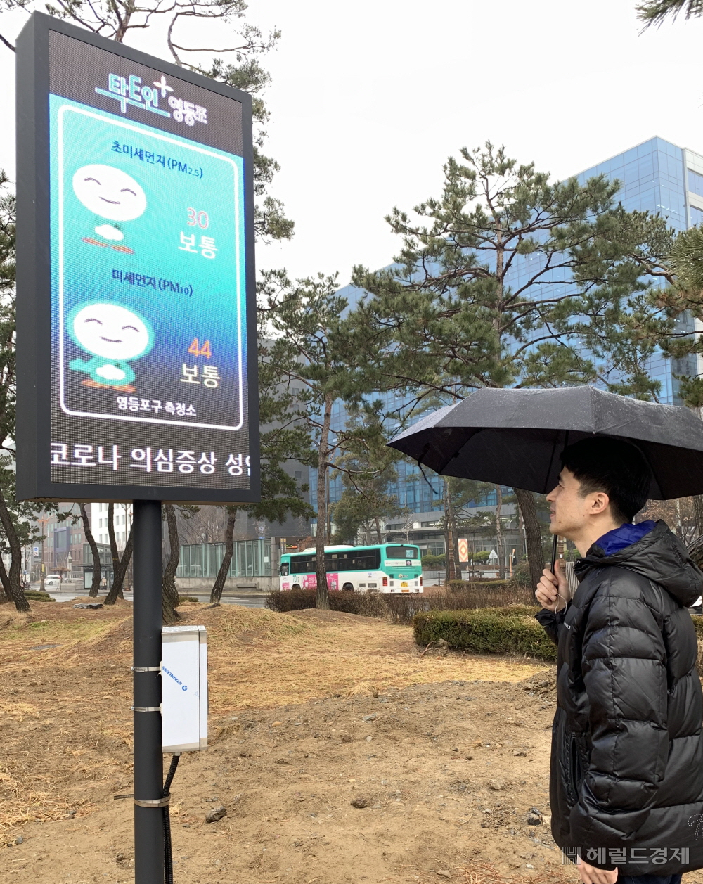 한 주민이 미세먼지 정보를 알려주는 미디어보드를 보고 있다. [영등포구]