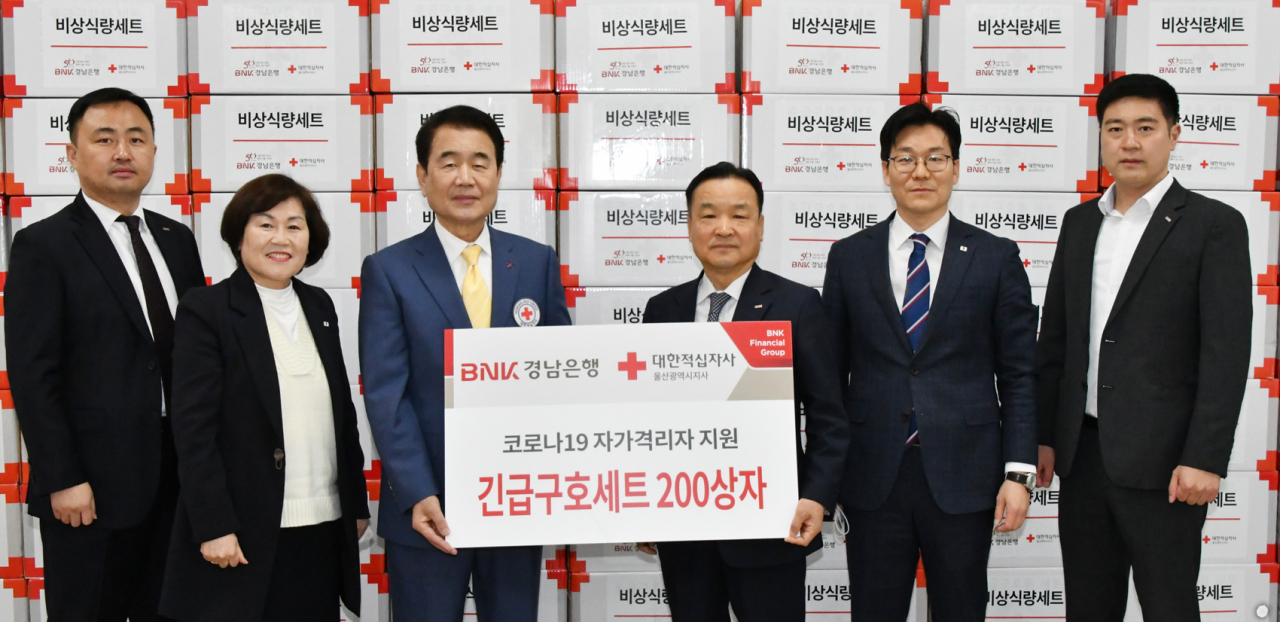 BNK경남은행 한기환 상무(사진 오른쪽 세번째)가 대한적십자사 울산광역지사 김철 회장(사진 오른쪽 네번째)에게 ‘코로나19 긴급구호세트 기탁 증서’를 전달하고 있다.