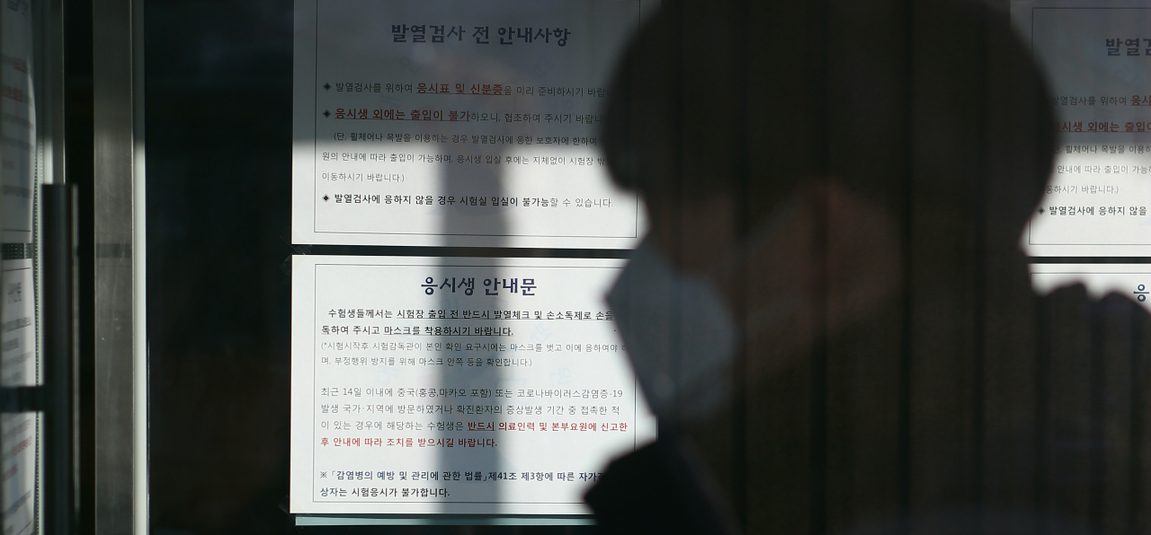 지난 2월 22일 대구 달서구 상원중에서 열린 법원 공무원 9급 공채 시험에서 시험장 입구에 신종 코로나바이러스 감염증(코로나19) 확산에 따른 안내문이 붙어 있다. 당시 법원행정처는 코로나19 확산에 대한 우려로 시험장 입구에서 수험생들에게 손 소독제를 제공하고 발열 체크를 했다. [연합]