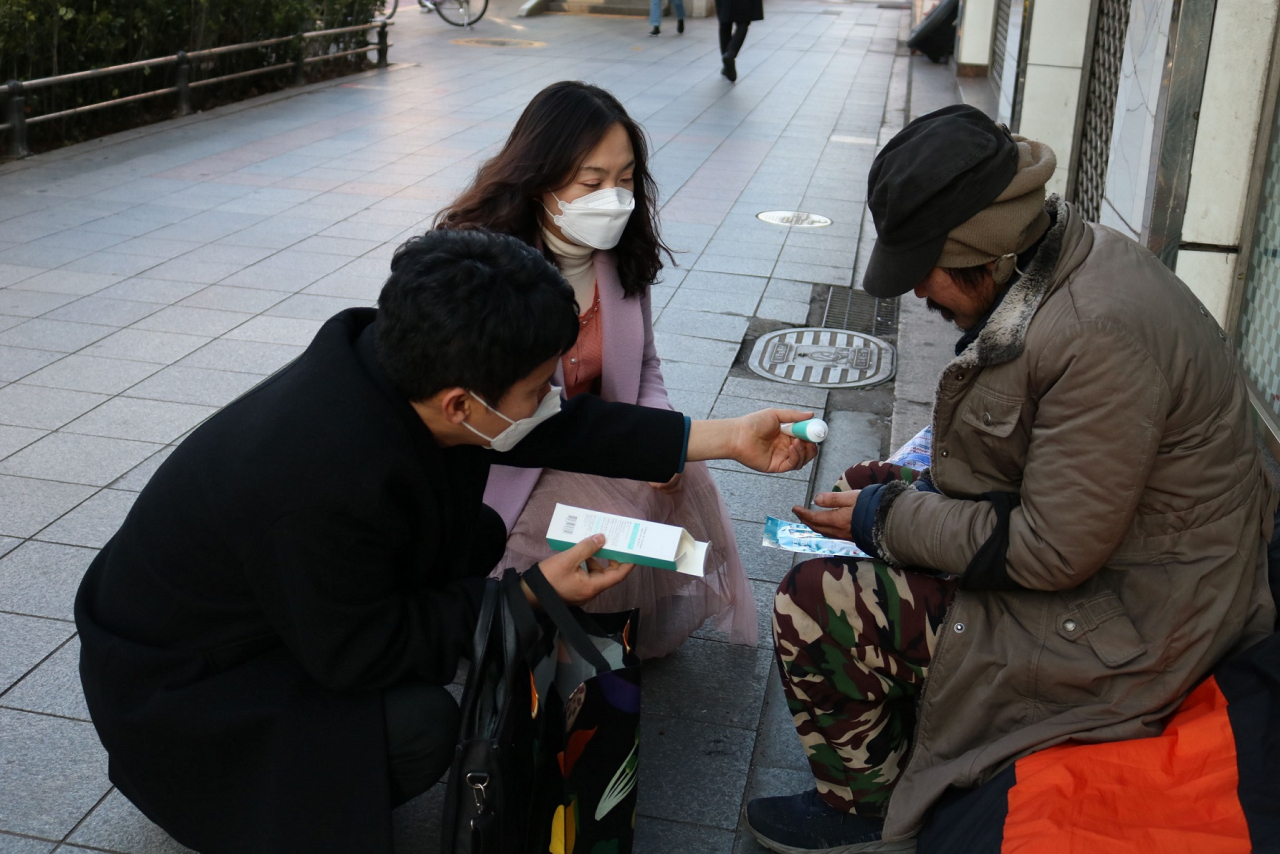 종로구청 직원들이 거리 노숙인에게 마스크를 전달하고 손세정제 사용법을 알려주고 있다. [종로구 제공]