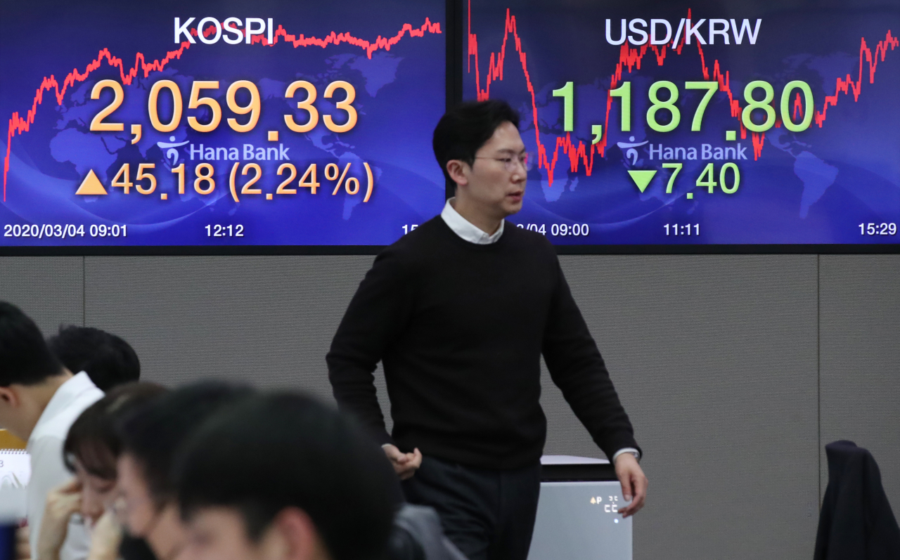 4일 오후 서울 을지로 하나은행 본점 딜링룸에서 한 외환 딜러가 현황판 앞을 지나고 있다. 연합뉴스
