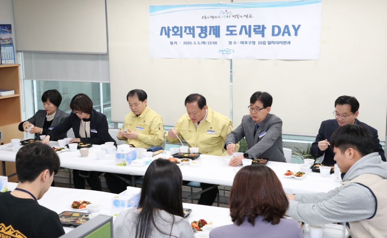 5일 유동균 마포구청장이 코로나19 확산으로 판로개척에 어려움을 겪는 사회적경제기업의 도시락을 공공구매해 직원들과 함께 점심식사를 하고 있다. [마포구 제공]