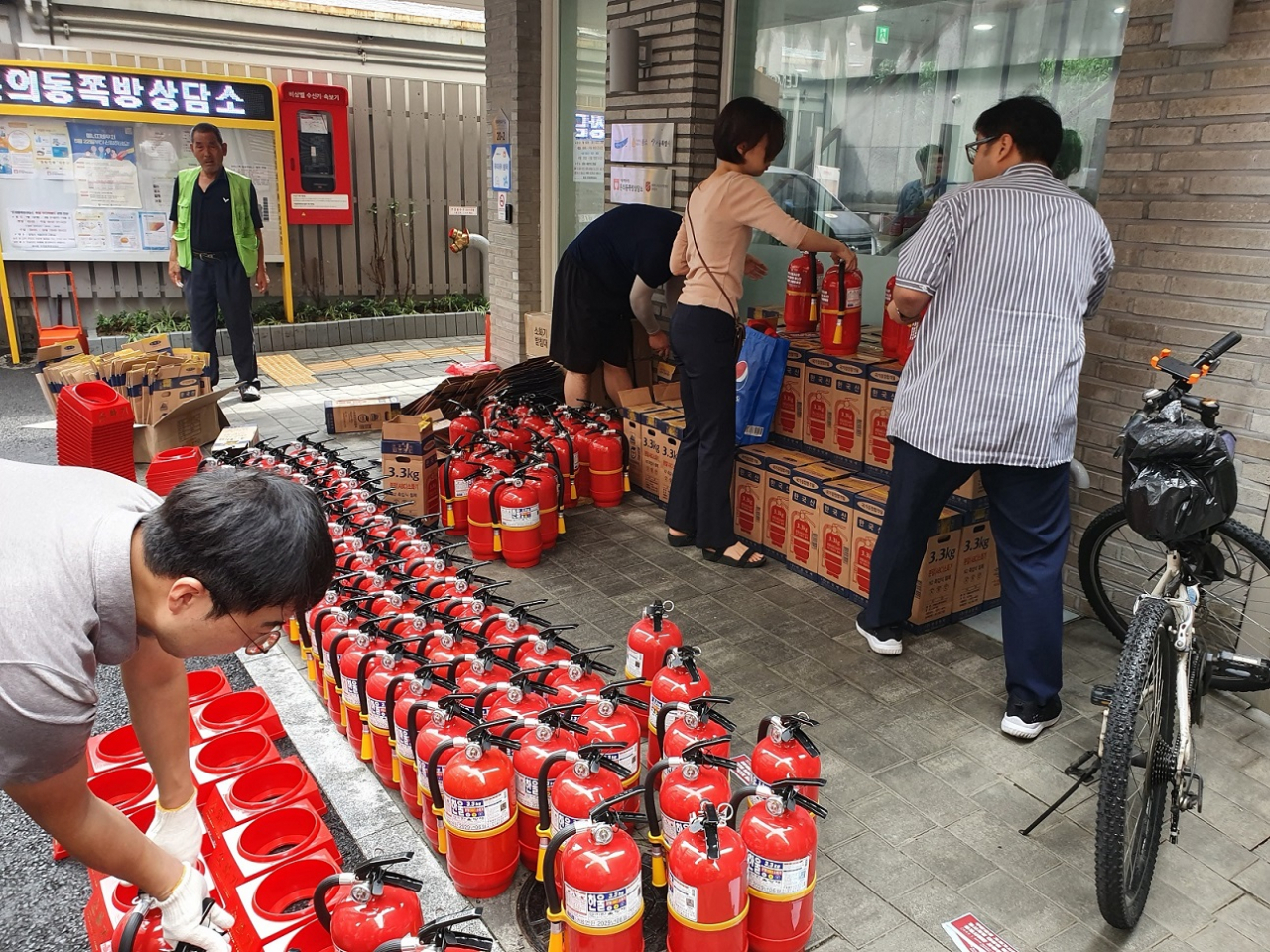 작년 8월 돈의동 쪽방상담소 앞에서 소화기를 지급하는 구청 관계자들의 모습. [종로구 제공]