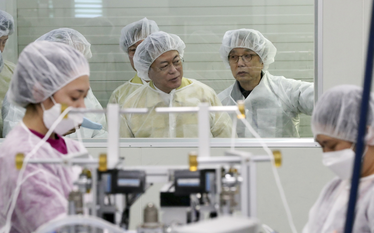 President Moon Jae-in looks around the production line of mask maker Wooil C&Tech in Pyeongtaek, Gyeonggi Province on Friday. Yonhap