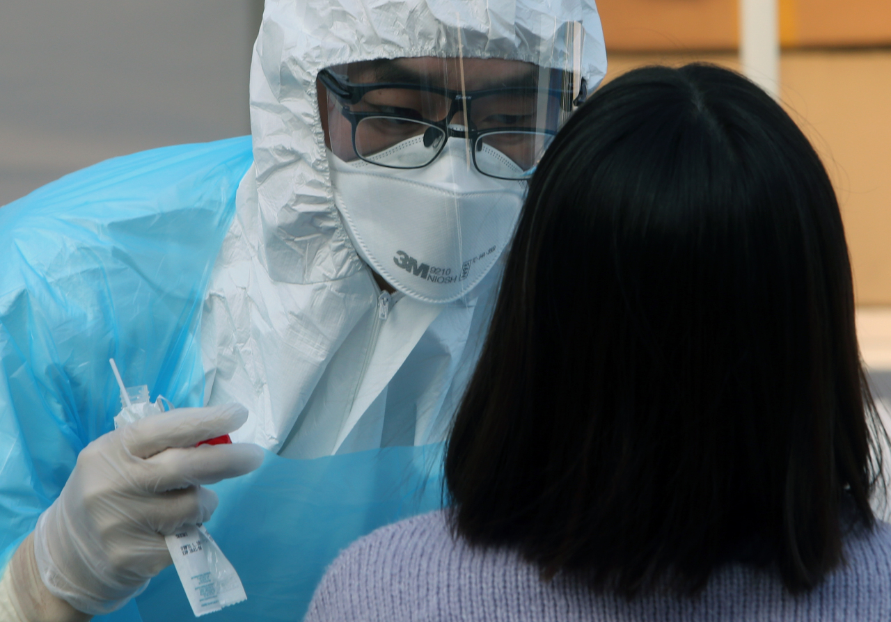 A staff at a hospital in Gangneung, Gangwon Province collects samples for testing on Saturday. Yonhap