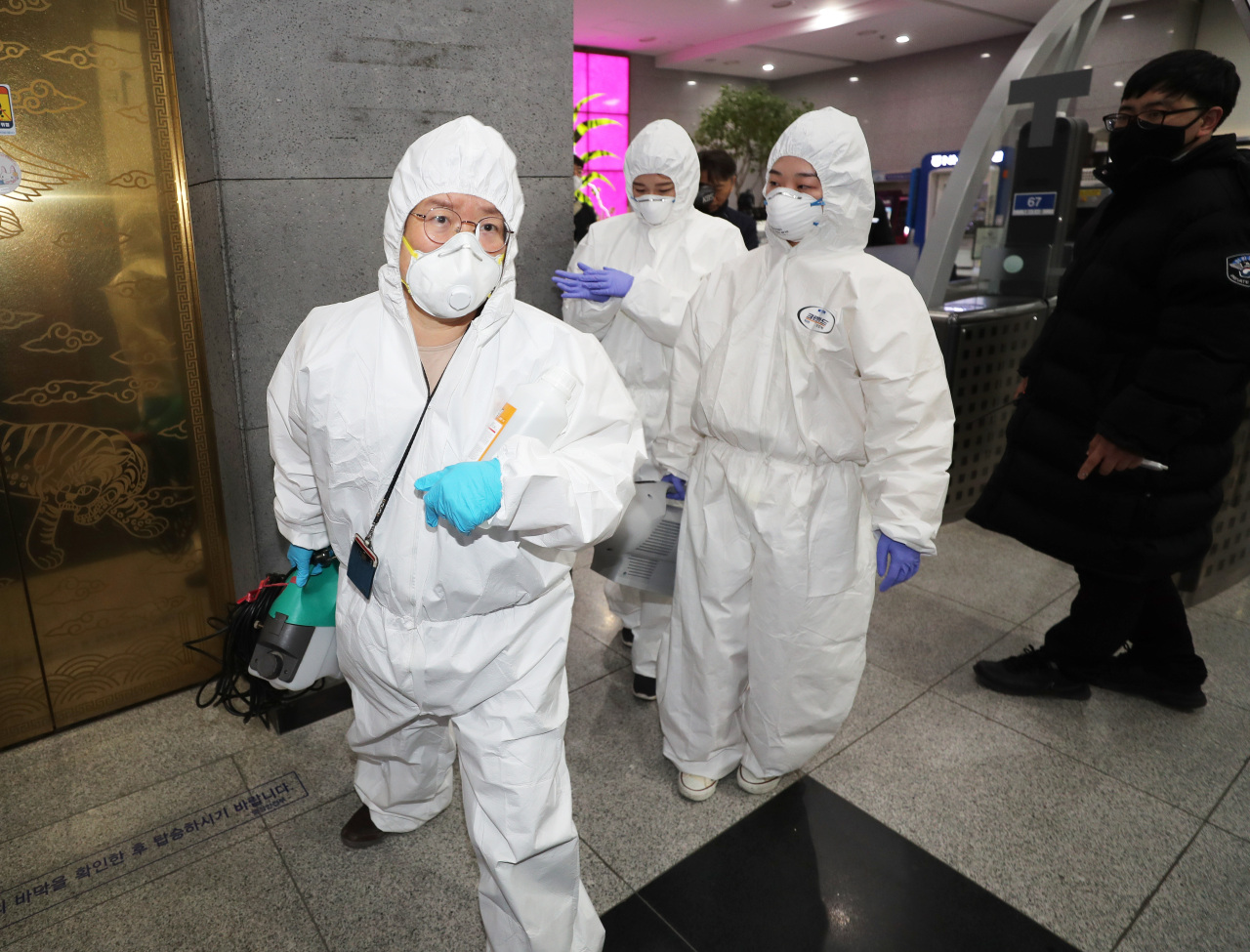 Officials enter the Ministy of Health and Welfare in Sejong on Saturday to disinfect the building where a public servant was diagnosed with COVID-19. Yonhap